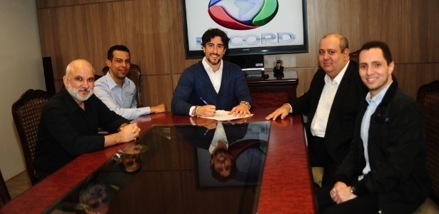 Marcus Vinícius Vieira (na frente, à esquerda), novo CEO da Rede Record, com Marcos Mion na assinatura do contrato do apresentador com o canal em junho de 2014