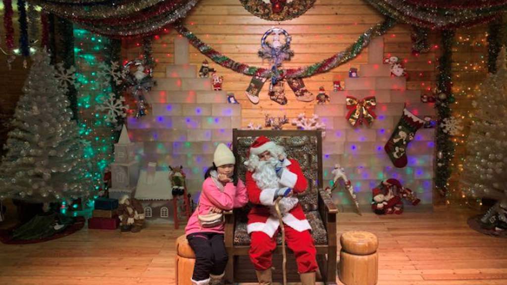 Visitante tira foto com Papai Noel, interpretado pelo finlandês Ville Haapassallo, em parque temático perto de Mohe, na China