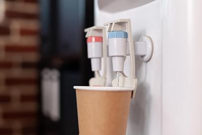 close-up-of-disposable-cup-on-water-cooler-in-startup-office-water-dispenser-with-hot-and-cold-faucet-used-for-refreshment-and-beverage-in-space-purified-mineral-water-in-gallon.jpg