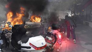 Manifestantes vestindo capas pretas atearam fogo a veículos nas ruas das principais cidades francesas
