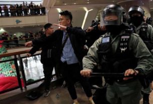 Polícia chega para dispersar manifestantes antigoverno que protestam dentro de um shopping na véspera de Natal em Hong Kong, China