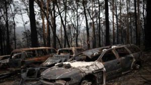 Carros destruídos por incêndio florestal no vilarejo de Mogo, na Austrália