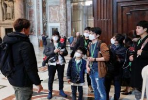 Turistas usam máscara de proteção durante visita à Basílica de São Pedro, no Vaticano