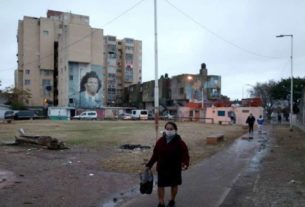 Mulher com máscara de proteção caminha em rua de Fuerte Apache, nos arredores de Buenos Aires, em meio à pandemia de covid-19