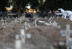 Coveiros enterram pessoas que morreram de covid-19 no Rio de Janeiro