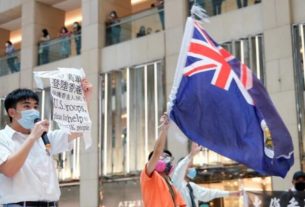 Manifestantes pró-democracia com máscaras de proteção empunham bandeira colonial britânica de Hong Kong