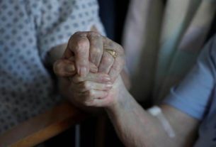 Pacientes idosos seguram as mãos durante breve visita em hospital de Cambridge