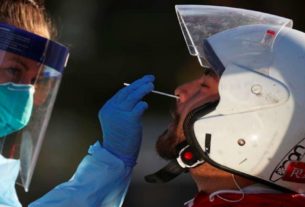Agente da saúde realiza exame de coronavírus em motoqueiro em Nova Gales do Sul, na Austrália