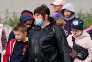Mulher acompanha crianças na Ucrânia